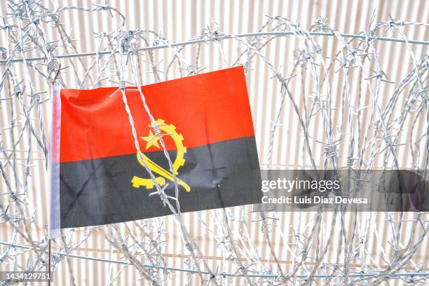 flag of angola on barbed wire - angola flag stock pictures, royalty-free photos & images