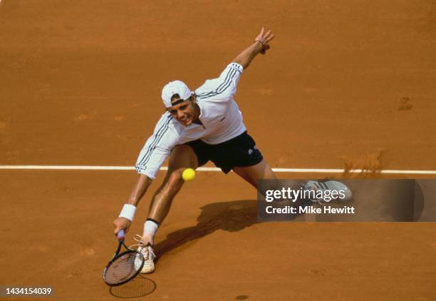 Paul-Henri Mathieu from France reaches to play a forehand return to Andre Agassi of the United States during their Men's Singles Fourth Round match...