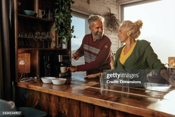 senior couple making espresso at home. - espressomachine stockfoto's en -beelden