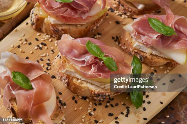 apple and brie crostini with prosciutto - crostini imagens e fotografias de stock