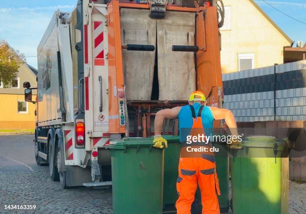 garbage worker lifts two garbage cans to the truck - trailer trash stock pictures, royalty-free photos & images