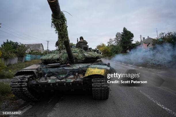 Ukrainian tank crew start a tank with belches of exhaust fumes after making adjustments to a captured Russian T-72B tank, as they drive it toward the...