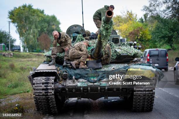 Ukrainian soldiers make adjustments to a captured Russian T-72B tank, as they drive it toward the northeastern Kharkiv region frontline on a road to...