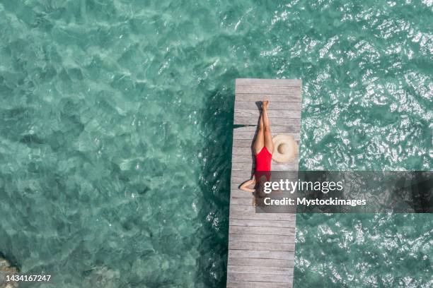 vista del drone della donna che si rilassa sul molo sopra la laguna - molo foto e immagini stock