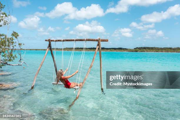 drohnenansicht von junge frau, die an einem sonnigen tag in einer wunderschönen lagune spaß hat - beach woman stock-fotos und bilder