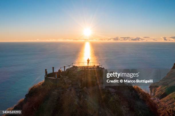 person standing on top of hill overlooking the sunset, madeira island, portugal - islande fotografías e imágenes de stock