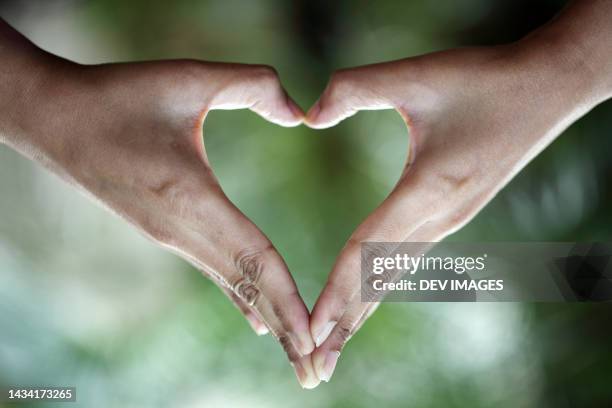 female hands gestured in heart shape - emoji hand heart stock pictures, royalty-free photos & images