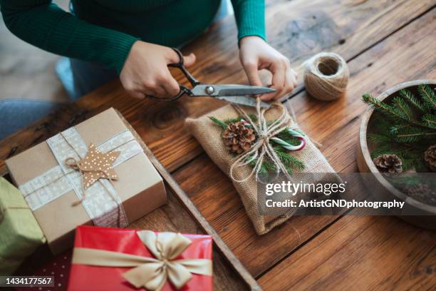 donna che prepara il regalo di natale in stile rustico con materiali a rifiuti zero. - avvolto foto e immagini stock
