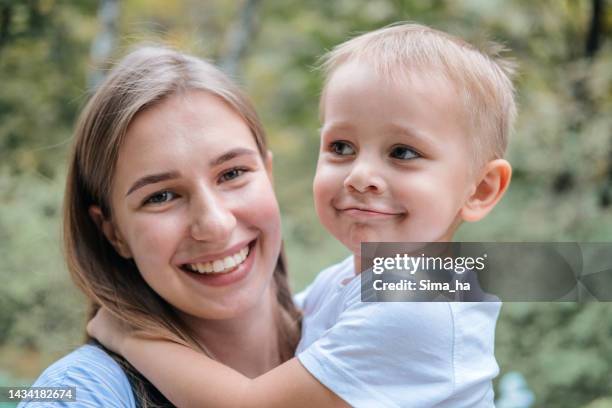 portrait of a smiling young mother and son in the park - park ha stock pictures, royalty-free photos & images