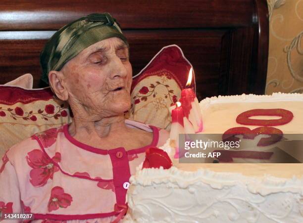 Picture taken on July 8, 2010 shows Georgian woman Antisa Khvichava blowing out candles on her cake during her 130th birthday party in the village of...