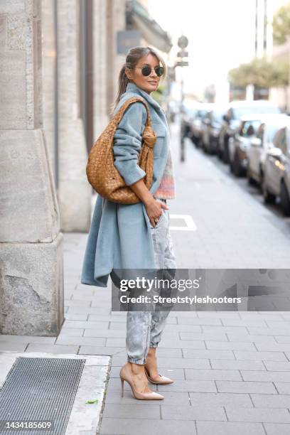 Influencer Gitta Banko wearing a multicolored striped knitted pullover by Roberto Collina, a long grey faux fur coat by Betta Corradi, a camel...