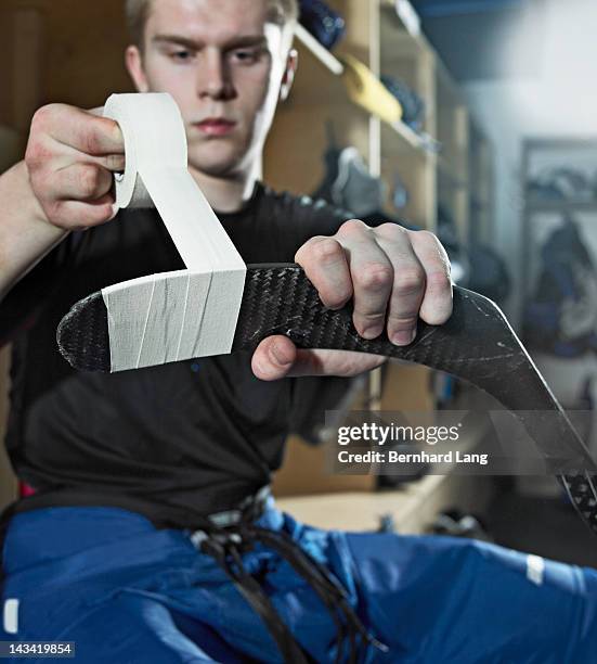 ice hockey player taping hockey stick - hockey stick stock pictures, royalty-free photos & images