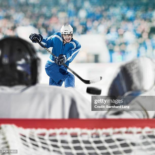 ice hockey player shooting on goal - eishockey tor stock-fotos und bilder