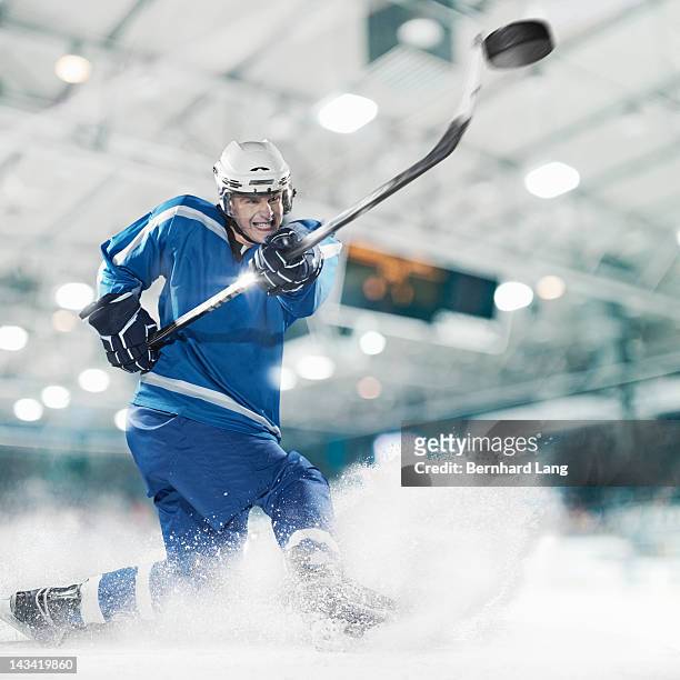 ice hockey player shooting puck - ice hockey stock-fotos und bilder