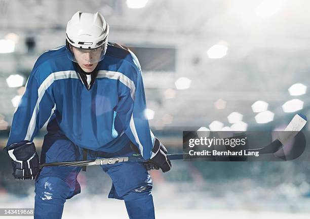 ice hockey player holding stick - ice hockey equipment stock pictures, royalty-free photos & images