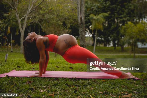 pregnant black woman doing yoga outdoors - showus yoga stock pictures, royalty-free photos & images