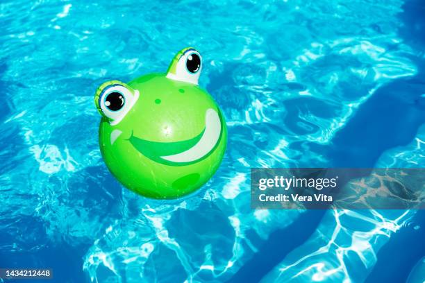 side view of plastic animal inflatable ball on swimming pool at summer with water waves - plastic pool stock-fotos und bilder