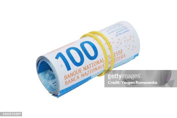 hundred swiss frank bills rolled into a roll isolated on white background - franken stockfoto's en -beelden