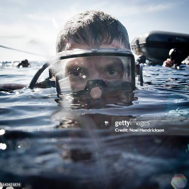 a scuba diver emerges from the water - scuba mask stockfoto's en -beelden