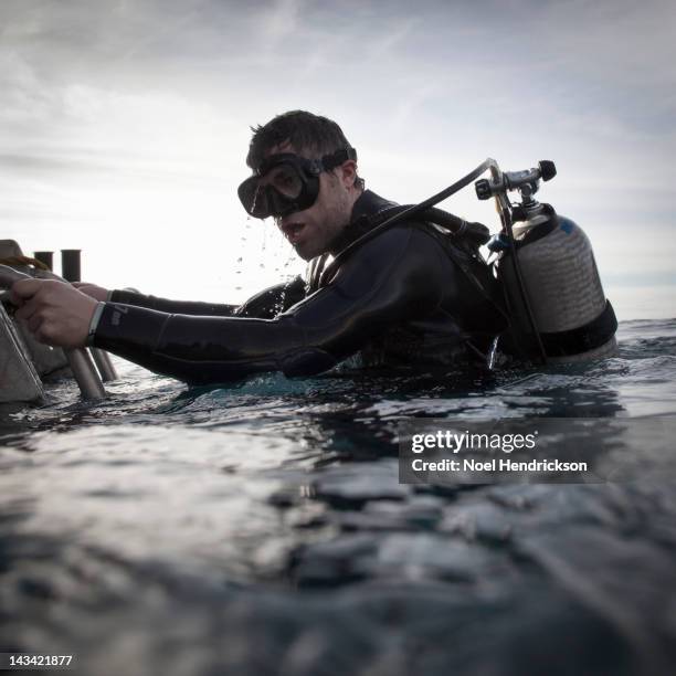 a scuba diver emerges from the water - aqualung diving equipment stock pictures, royalty-free photos & images