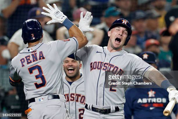 Jeremy Pena of the Houston Astros reacts with Alex Bregman after hitting a solo home run during the eighteenth inning against the Seattle Mariners in...