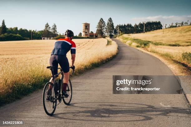 vista trasera de un ciclista en el campo - ciclista profesional fotografías e imágenes de stock