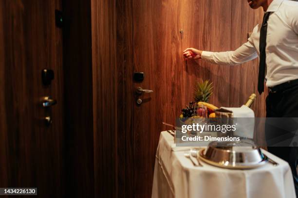 servizio in camera bussando alla porta della camera d'albergo. - bellhop foto e immagini stock