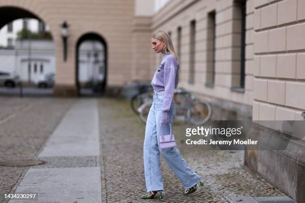 Carolin Niemczyk wearing Rotate lilac knit logo sweater, Jacquemus lilac bag, Gina Tricot wide leg baby blue denim jeans and Amina Muaddi green...