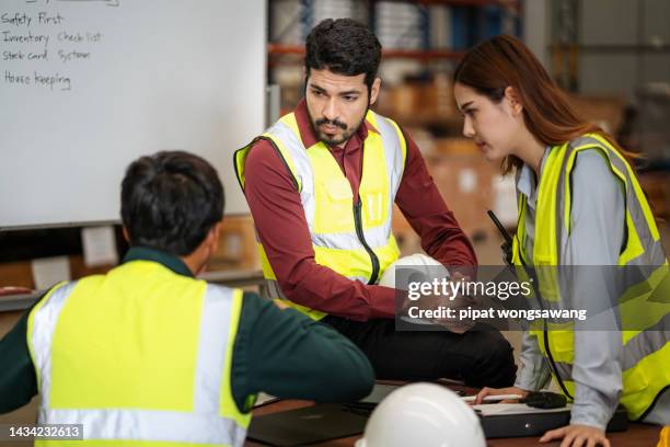 warehouse worker is having a brainstorming meeting. inspecting goods in a storage and distribution center. - community safety stock pictures, royalty-free photos & images