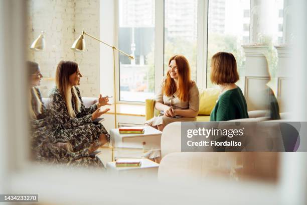 three women in armchairs and talking. reflection in the mirror - meeting room stock-fotos und bilder