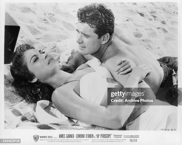 Andra Martin and James Garner laying on the beach together in a scene from the film 'Up Periscope', 1959.