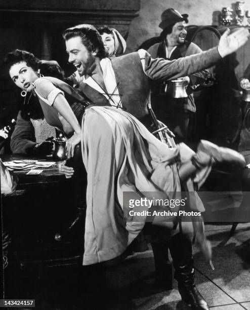 Man about to spank Rita Moreno in a scene from the film 'The Vagabond King', 1956.