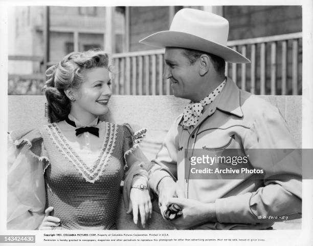 Gail Davis and Gene Autry sharing smiles in a scene from the film 'Valley Of Fire', 1951.