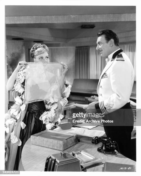 Marina Koshetz looking through lace handkerchief at George Brent in a scene from the film 'Luxury Liner', 1948.