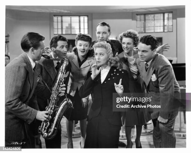 Marilyn Maxwell does a number with bandsmen and dancers in the cast in a scene from the film 'Swing Fever', 1943.