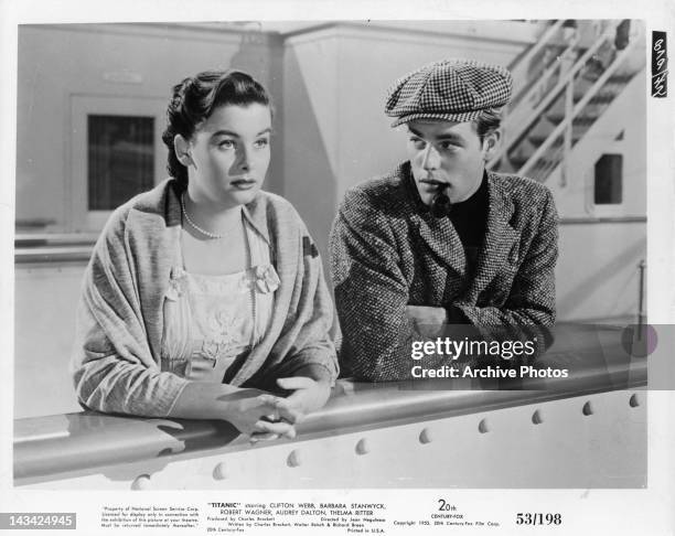 Audrey Dalton and Robert Wagner leaning against railing of the ship in a scene from the film 'Titanic', 1953.