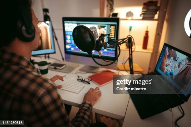 giovane uomo che modifica video nell'ufficio di casa - video editing foto e immagini stock