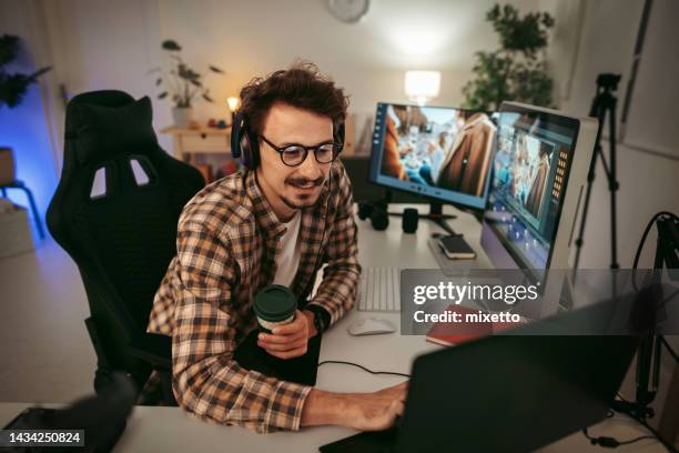 junger mann beim bearbeiten von videos im home office - multimedia stock-fotos und bilder