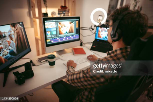 giovane uomo che modifica video nell'ufficio di casa - video editing foto e immagini stock