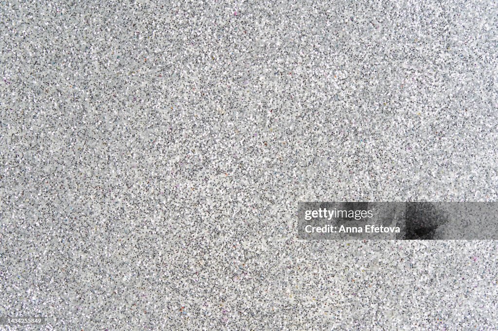 Festive silver glittering background. New Year and Christmas celebration concept. Bright backdrop for your design with copy space.