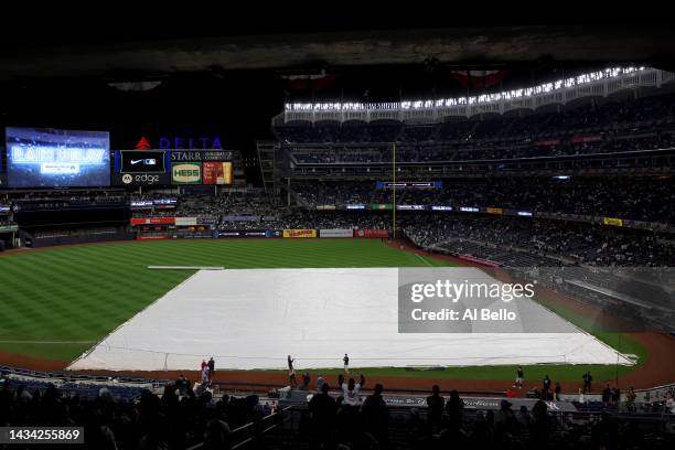 Tarp covers the infield during a rain delay prior to game five of the American League Division Series between the Cleveland Guardians and New York...