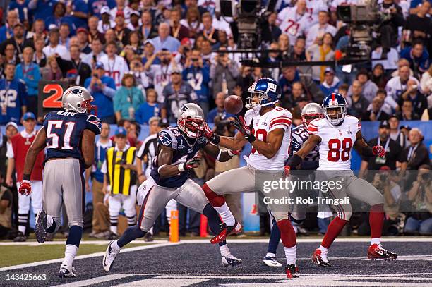 Victor Cruz of the New York Giants receives the ball for a touchdown in the first quarter during Super Bowl XLVI against the New England Patriots at...