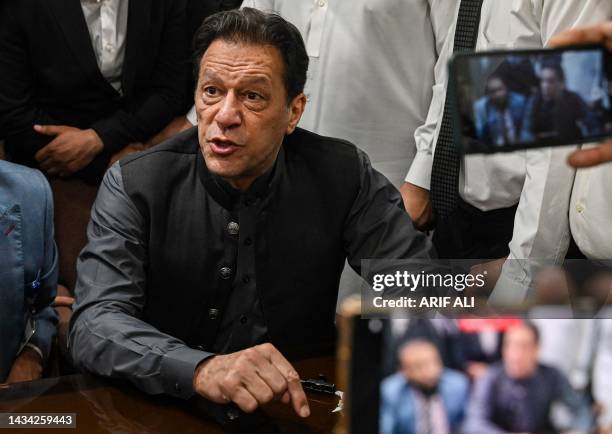 Pakistan's former prime minister, Imran Khan gestures after arriving at a registrar office in Lahore High court to sign surety bonds for bail in...