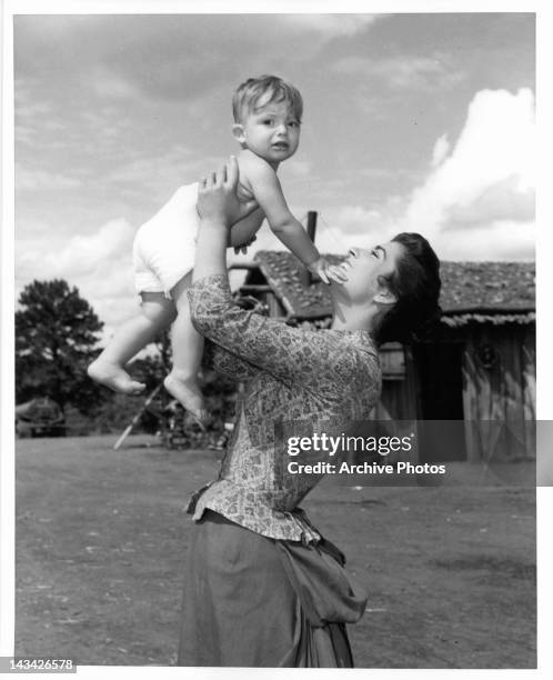 Irene Papas gets acquainted with youthful visitor on the set of the in a scene from the film 'Tribute To A Bad Man', 1956.