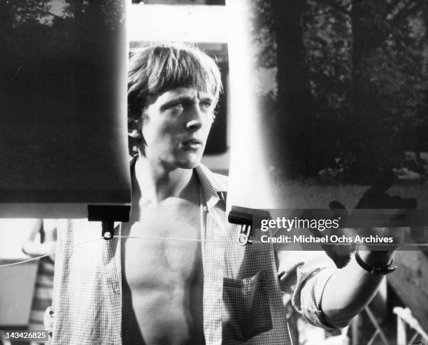 David Hemmings studies the blow ups he made of films of an embracing couple in London park in a scene from the film 'Blow Up', 1966.