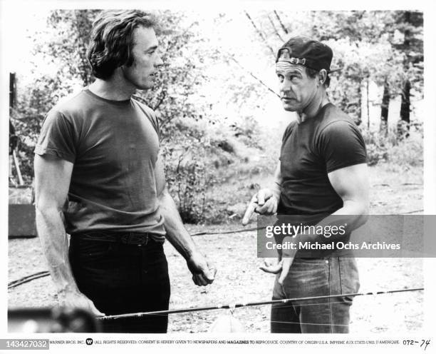 Clint Eastwood with a fishing pole in his hand talking with Geoffrey Lewis in a scene from the film 'Any Which Way But Loose', 1978.