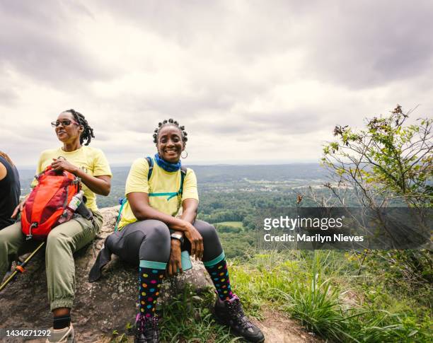 women sit down to rest during their hike - "marilyn nieves" stock pictures, royalty-free photos & images