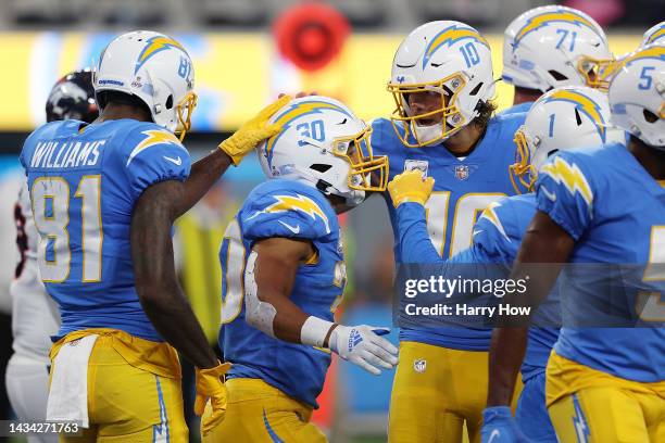 Austin Ekeler and Justin Herbert of the Los Angeles Chargers celebrate a touchdown against the Denver Broncos during the second quarter at SoFi...