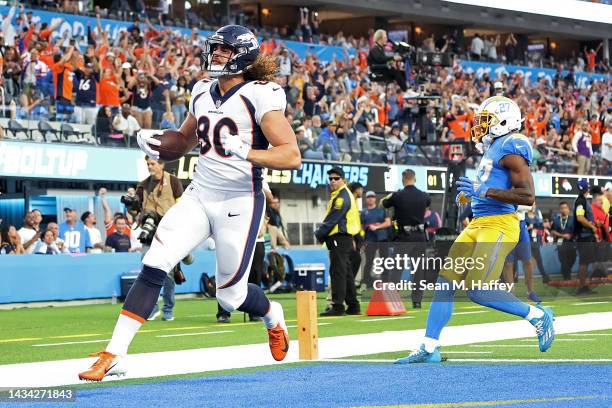 Greg Dulcich of the Denver Broncos scores a touchdown in front of J.C. Jackson of the Los Angeles Chargers during the first quarter at SoFi Stadium...