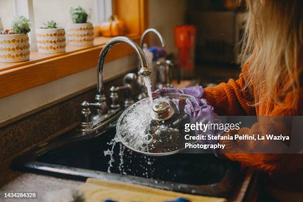 woman washing dishes - water wastage stock pictures, royalty-free photos & images